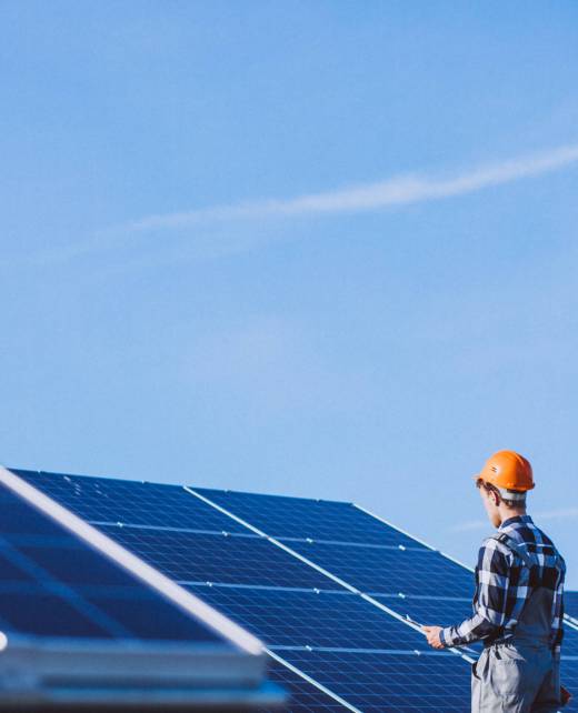 Man worker in the firld by the solar panels